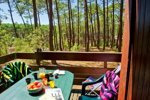 - une table avec un bol de fruits sur une terrasse couverte dans l'établissement VTF Les Bruyères, à Maubuisson