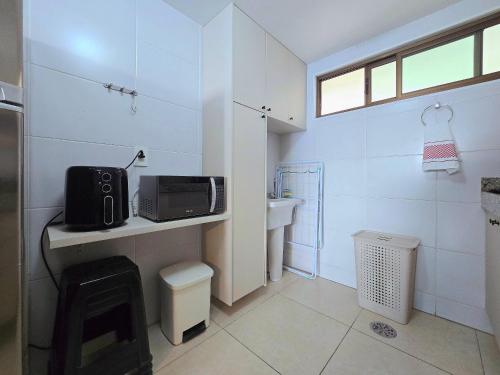 a bathroom with a sink and a microwave on a counter at Luxor Paulo Miranda Cabo Branco by Hosppedar in João Pessoa