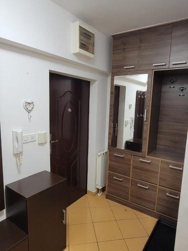 a bathroom with wooden cabinets and a mirror at Apartman Aylin in Tuzla