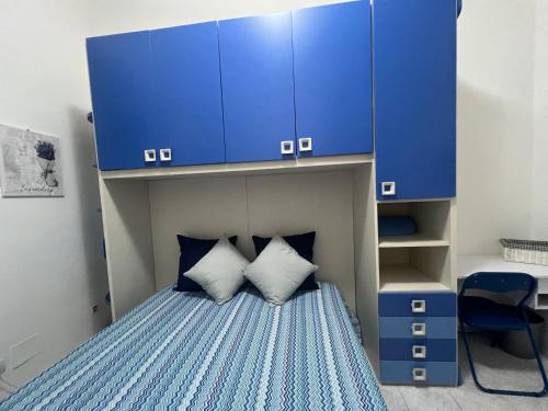 Un dormitorio pequeño con armarios azules y una cama. en La casetta di lalla, en Civitavecchia