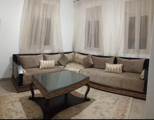 a living room with a couch and a coffee table at Maison pres plus Grand Bazar d'Afrique Souk El Had in Agadir