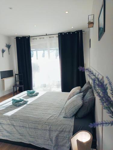 une chambre avec un lit et une grande fenêtre dans l'établissement Suite indépendante - Les Lavandes, à Peyruis