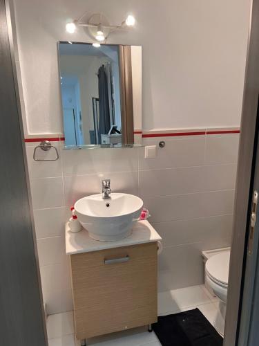 a bathroom with a sink and a mirror and a toilet at Small budjet deluxe studio down town in Thessaloniki