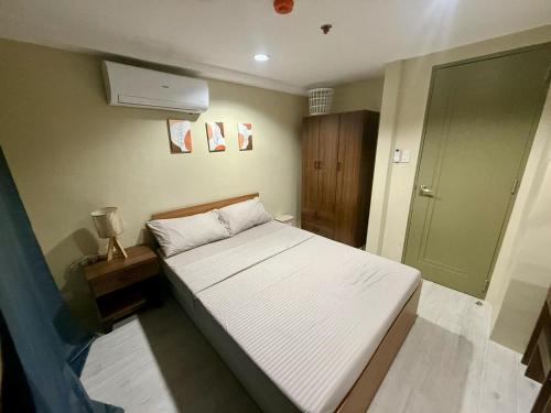 a small bedroom with a bed and a fan at Cityscape Grand Tower Cebu - 2 Bedrooms with Balcony Close to Ayala Mall - New Condo in Cebu City