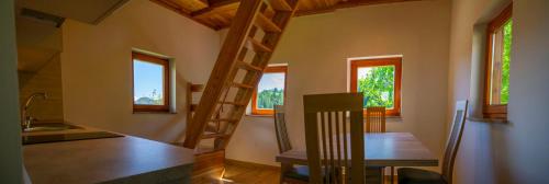 a room with a kitchen with a wooden table and some windows at Wooden Chalet - Homestead Vrhovc in Železniki
