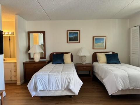 - une chambre avec 2 lits et 2 tables avec des lampes dans l'établissement Island Vacations, à Honolulu