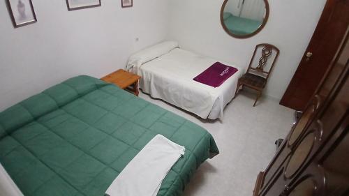 a small room with two beds and a mirror at Habitacion Privada Familiar Toledo in Toledo