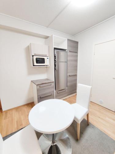 a white kitchen with a white table and a refrigerator at Reipas in Kotka