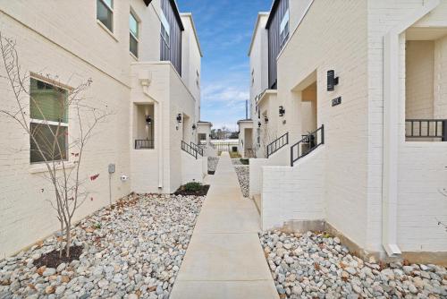 a walkway between two buildings with rocks between them at Victory Villa - Lux Townhome Walk 2 Globe Life - Rangers & Cowboys Stadiums in Arlington