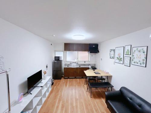 a living room with a table and a kitchen at 泊心の舍 in Osaka