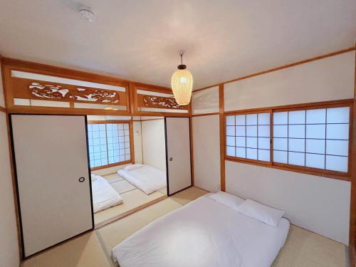 a room with two beds and two windows at 泊心の舍 in Osaka