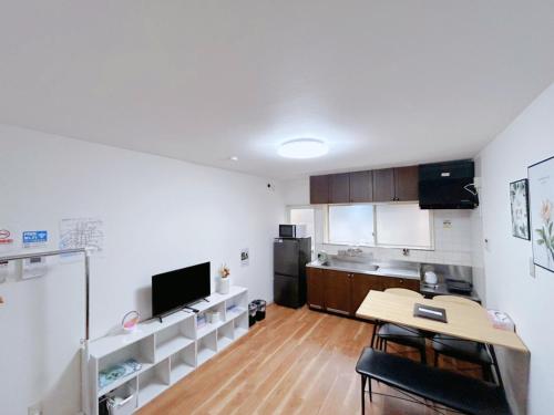 a living room with a table and a kitchen at 泊心の舍 in Osaka