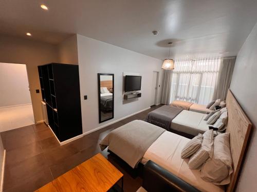 a hotel room with two beds and a television at 5411 Soho Hotel in Buenos Aires