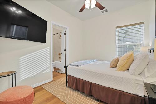 a bedroom with a bed and a flat screen tv at Victory Villa - Lux Townhome Walk 2 Globe Life - Rangers & Cowboys Stadiums in Arlington
