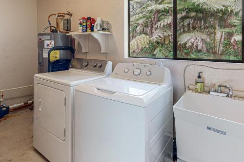 a white washer and dryer in a laundry room at Ekomomai Retreat in Volcano