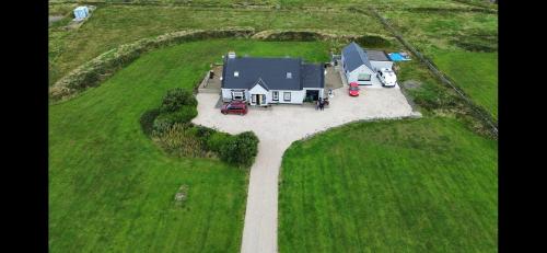 an aerial view of a house in a field at Cois na mara bridges of Ross V15 T677 in Kilbaha