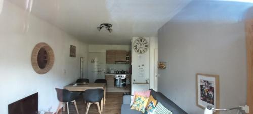 un salon avec une table et des chaises et une cuisine dans l'établissement T2 Calme assuré face à la pique les Ramel, à Luchon