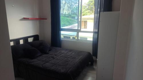 a bedroom with a bed and a large window at Apartamento en La Colina in Macanal