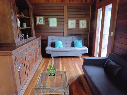 a living room with a couch and a table at Casa Floresta do Uaimii in Ouro Preto