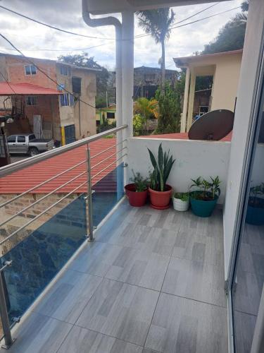 a balcony with potted plants on a house at Apartamento en La Colina in Macanal