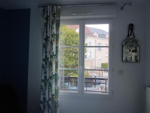 a window with a view of a city at 2 chambres d'hôtes in Wissous