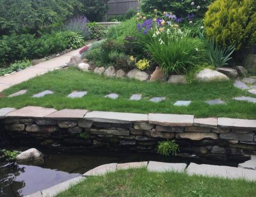 a garden with a stone retaining wall and a pond at Peaceful Oasis on Munjoy Hill 2nd flr 3BR parking in Portland