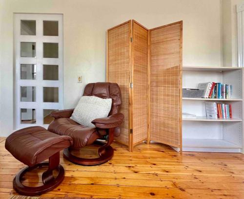 a living room with a chair and a book shelf at Peaceful Oasis on Munjoy Hill 2nd flr 3BR parking in Portland