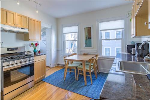 a kitchen with a wooden table and a kitchen with a sink at Peaceful Oasis on Munjoy Hill 2nd flr 3BR parking in Portland