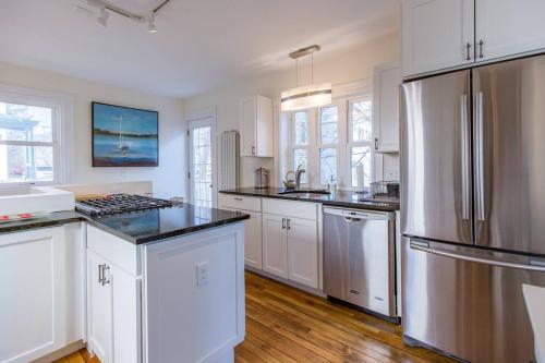 une cuisine avec des armoires blanches et un réfrigérateur en acier inoxydable dans l'établissement A Peaceful Oasis on Munjoy Hill - 4br2ba House & Parking, à Portland