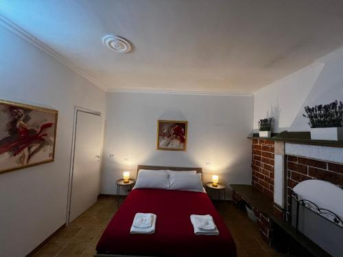 a bedroom with a red bed and a fireplace at LA MAISON aeroporto ciampino in Ciampino