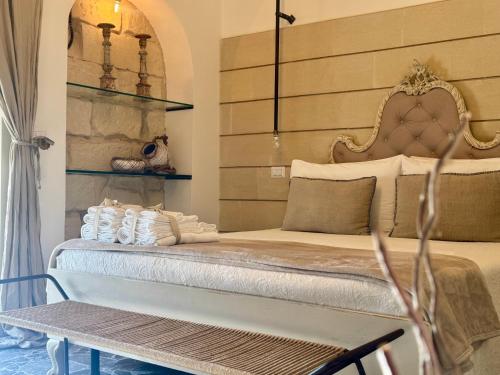 a bedroom with a bed and a bench and a table at HABITARE Lecce & Salento in Lecce