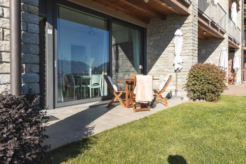 a patio with two chairs and a table in front of a window at Il Giardino Di Lory in Vercana