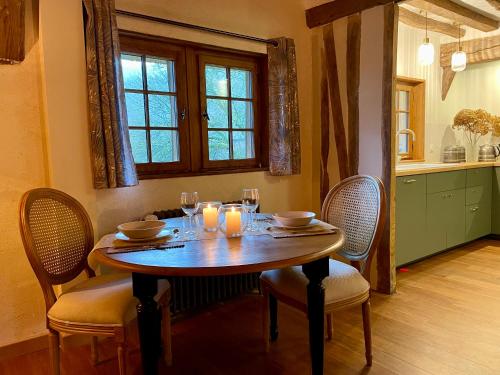 a dining room table with chairs and candles on it at Le Manoir du Perroy in Saint-Wandrille-Rançon