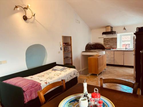 a room with a bed and a table and a kitchen at Al Castello in Valeriano Lunense