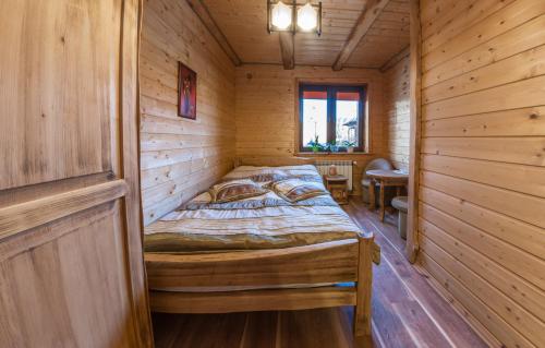 a bedroom with a bed in a wooden cabin at Domek Marców in Ustrzyki Dolne