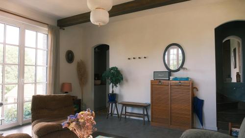 un salon avec un canapé et un miroir dans l'établissement Maison Maa, Maison de gardien, à 5min à pieds de St Valery sur somme le long du canal, à Boismont