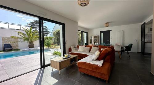 - un salon avec un canapé et une piscine dans l'établissement TY HEOL • la maison du soleil•, à Saint-Pierre-Quiberon