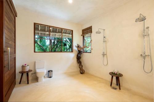 a bathroom with a shower and a toilet in a room at Upendo Beach Boutique Hotel Zanzibar in Michamvi