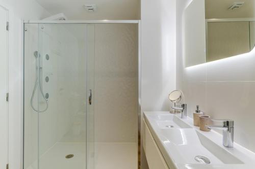a white bathroom with a shower and a sink at Atlantic Heights Varandas do Atlântico by Holiday Rental Madeira in Câmara de Lobos