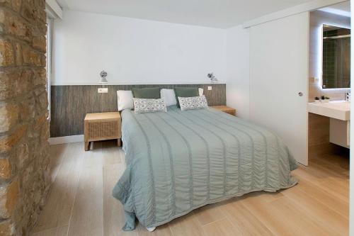 a bedroom with a large bed and a sink at Earra - Goxo - centro, 450m playa in Zarautz