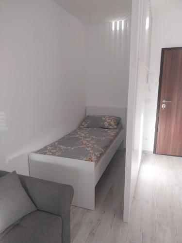 a small bedroom with a bed and a chair at Stan na dan in Žepče