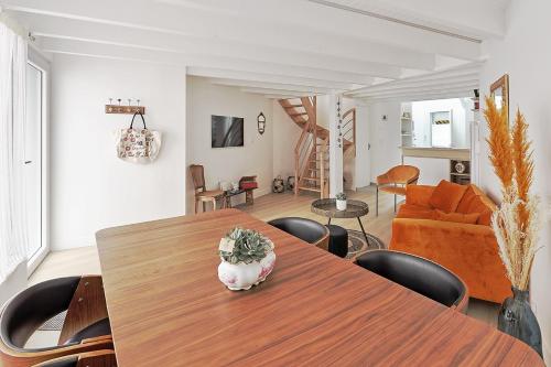 un salon avec une table et des chaises en bois dans l'établissement La Galerie Pornic - Maison Cedre, à Pornic