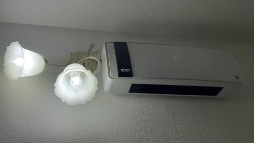 a toaster hanging on a wall next to a light at P I G Ó 's HOUSE in Budoni