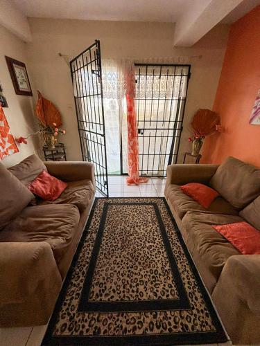 a living room with two couches and an open gate at Come Enjoy Lakeside Bungalow in Gros Islet