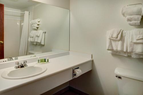een witte badkamer met een wastafel en een spiegel bij Lakeview Inns & Suites - Fort Saskatchewan in Fort Saskatchewan