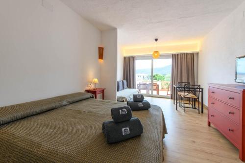 a hotel room with a bed and a balcony at Carpe Diem Cadaqués in Cadaqués