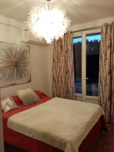 une chambre avec un lit et un lustre dans l'établissement Aix centre charmant T2 climatisé parc jourdan, à Aix-en-Provence