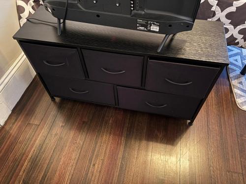 a black dresser with a television on top of it at HomeStay in Boston - Dorchester Fields Corner Area in Boston