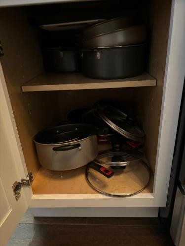 a cabinet with a pot and pans in it at HomeStay in Boston - Dorchester Fields Corner Area in Boston