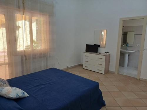 a bedroom with a blue bed and a sink at Villa Colle in Brancaleone Marina